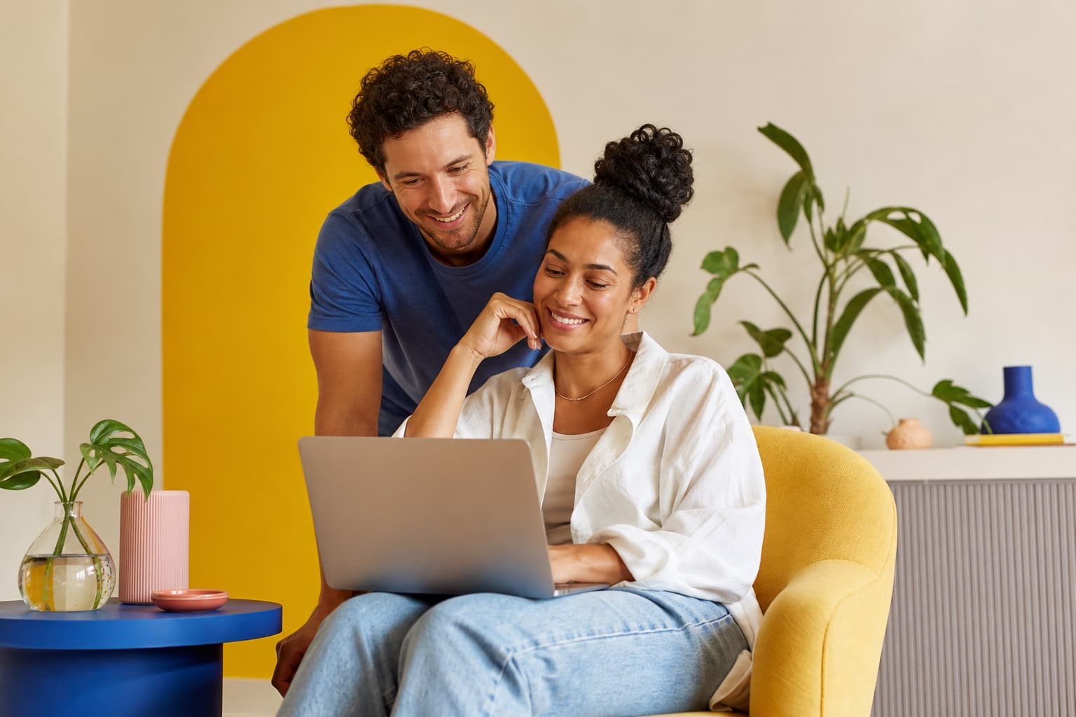 Two people sharing a warm, supportive moment while working together at a laptop